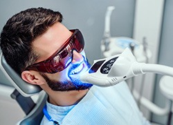 A man getting professional teeth whitening at the dentist