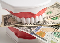 Fake teeth biting dollar bills