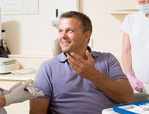 Smiling man talking to dentist