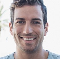 Young man grinning outdoors