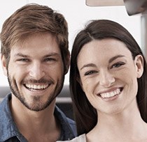 Smiling man and woman sitting next to each other