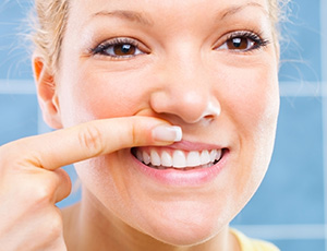 Woman looking at teeth in mirror