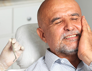 Man holding jaw in pain