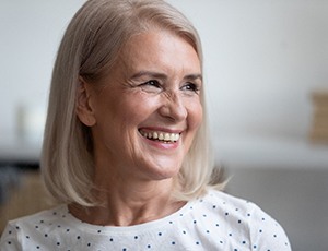 woman smiling after getting dental implants in Herndon