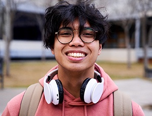 Closeup of teenage boy with black glasses smiling