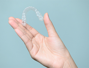 hand holding clear invisalign aligner