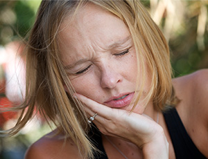 Woman holding jaw in pain