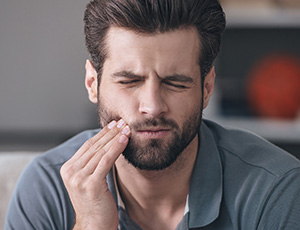 Man holding jaw in pain