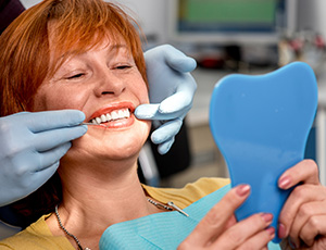 Senior woman looking at smile in mirror