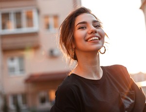 person walking down a city street and smiling