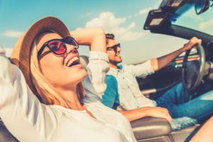 Woman on road trip in car smiling 