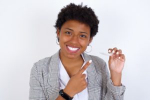 patient smiling and holding Invisalign