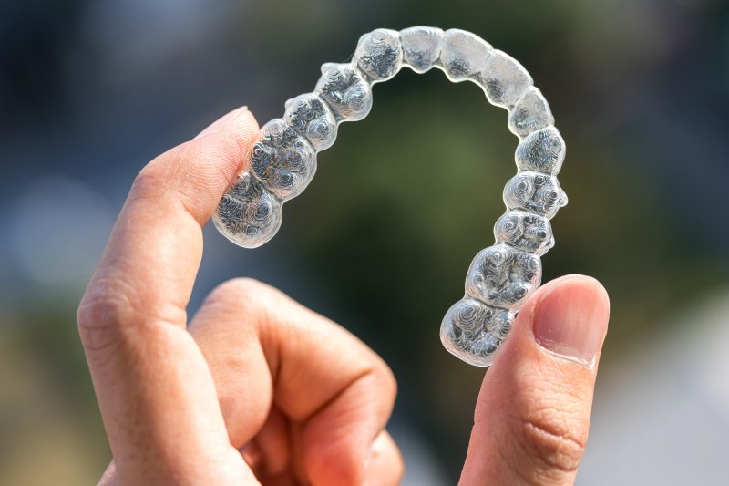 patient holding an Invisalign aligner