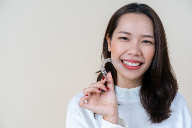 person holding up Invisalign clear aligner