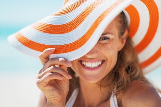 Woman smiling during the summer after receiving cosmetic treatment.