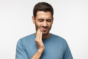 Man holding jaw in pain from toothache.